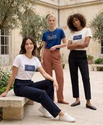 Trois femmes portant des t-shirts classiques Salut Fred blanc, écru et bleu Paris de la collection Rues de France dans une cour parisienne lumineuse
