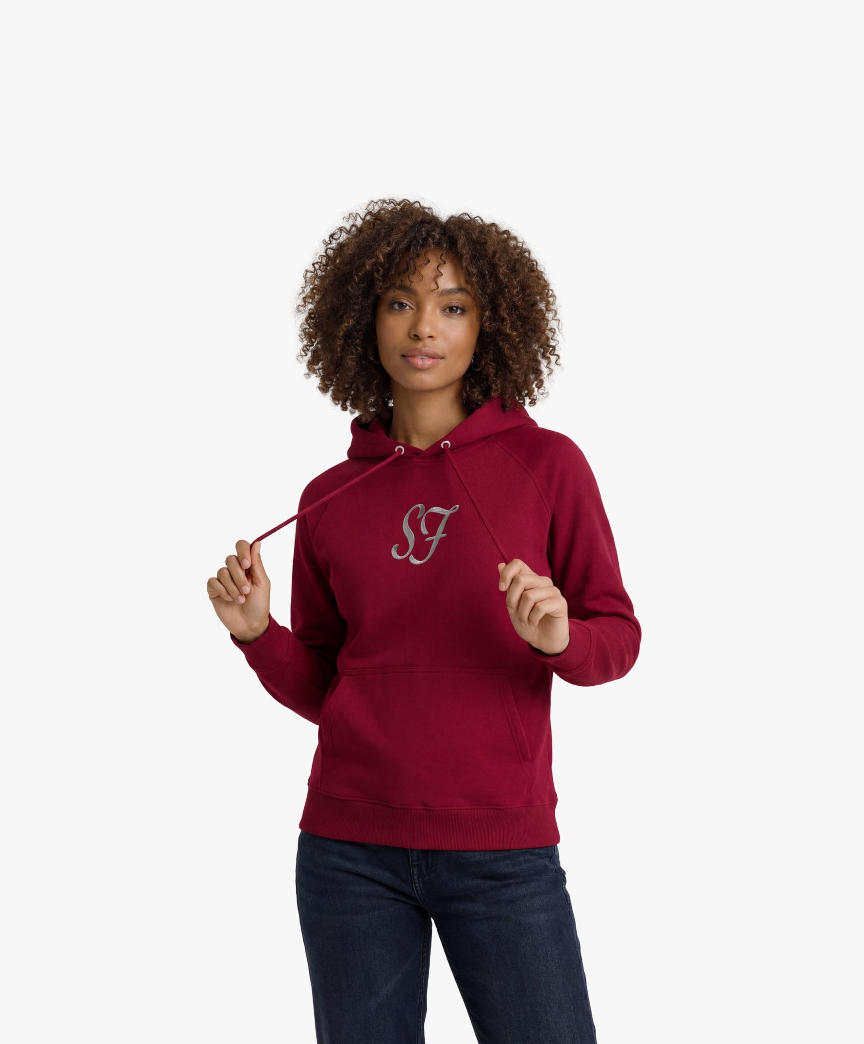 Vue de face d’une femme portant le hoodie bordeaux Salut Fred avec monogramme SF blanc brodé au centre de la poitrine et Salut Fred blanc brodé sur le poignet gauche