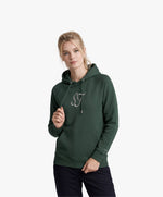Vue de face d’une femme portant le hoodie vert profond Salut Fred avec monogramme SF blanc brodé au centre de la poitrine et Salut Fred blanc brodé sur le poignet gauche