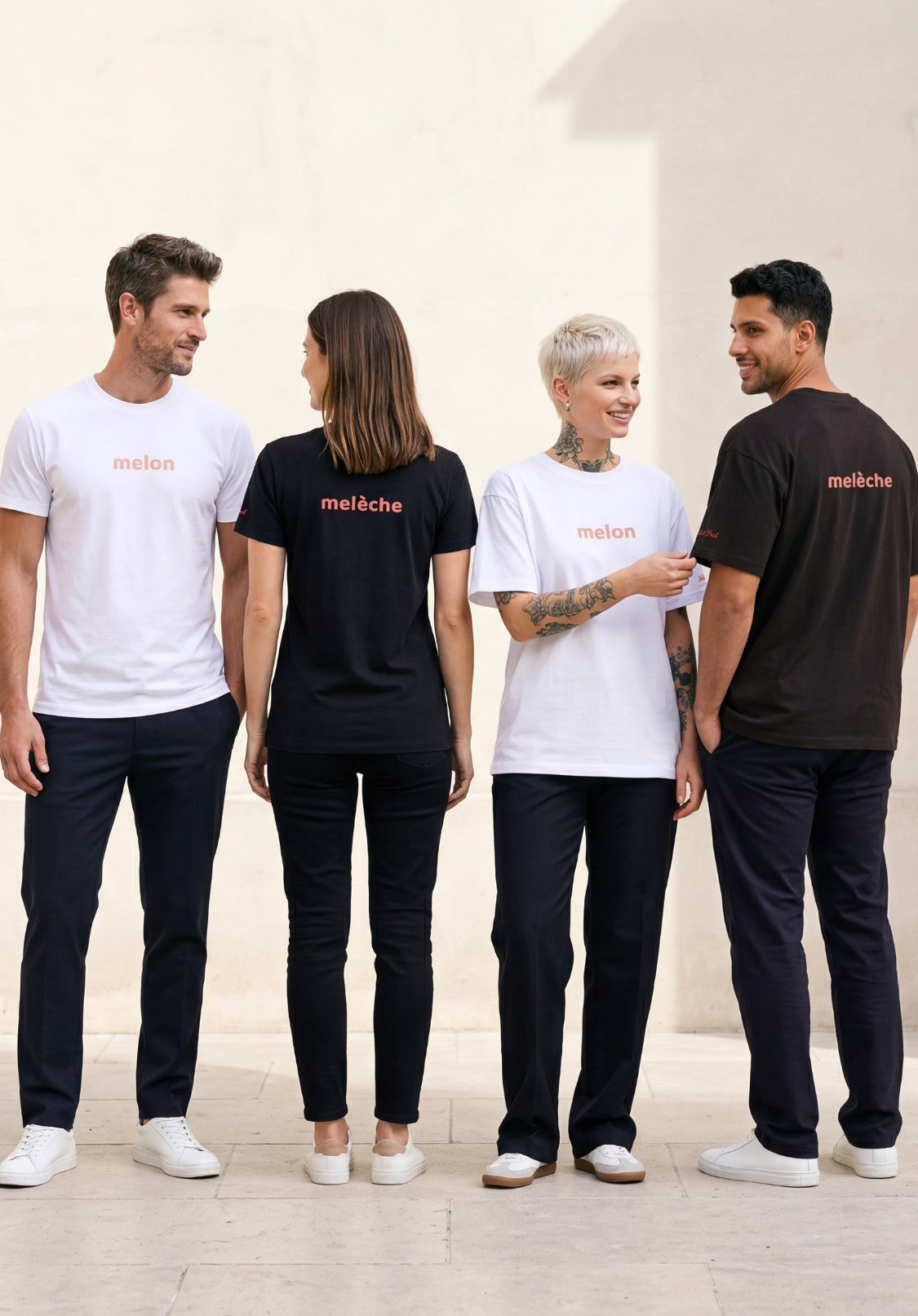 Groupe lifestyle présentant la ligne de t-shirts classiques et oversize « Melon Melèche » en noir et blanc, avec textes imprimés « melon » sur le devant et « melèche » au dos, ainsi que logo Salut Fred sur la manche gauche, dans une cour parisienne minimaliste.