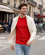 Vue de face d’un homme portant un t-shirt classique rouge Salut Fred avec slogan « Tu baises dans mon estime » dans une rue parisienne animée