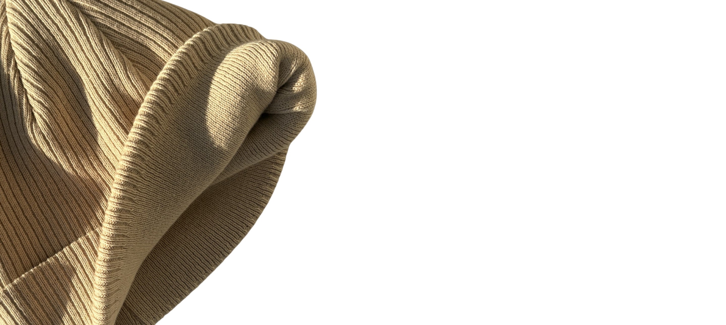 Vue intérieure d’un bonnet beige en coton bio à maille côtelée épaisse avec revers large et texture douce.