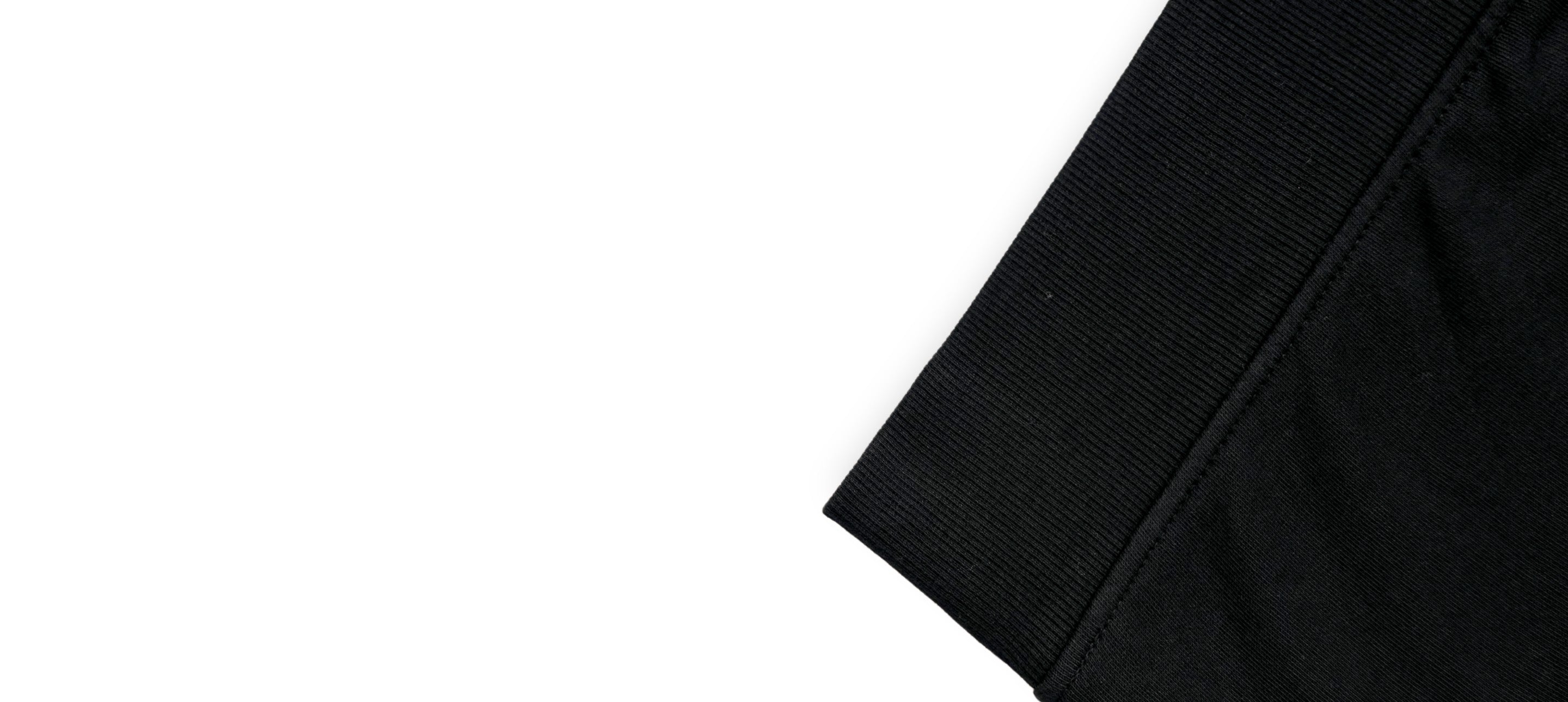 Détail de l’ourlet en bord-côte d’un sweatshirt noir avec finition structurée et maintien souple.