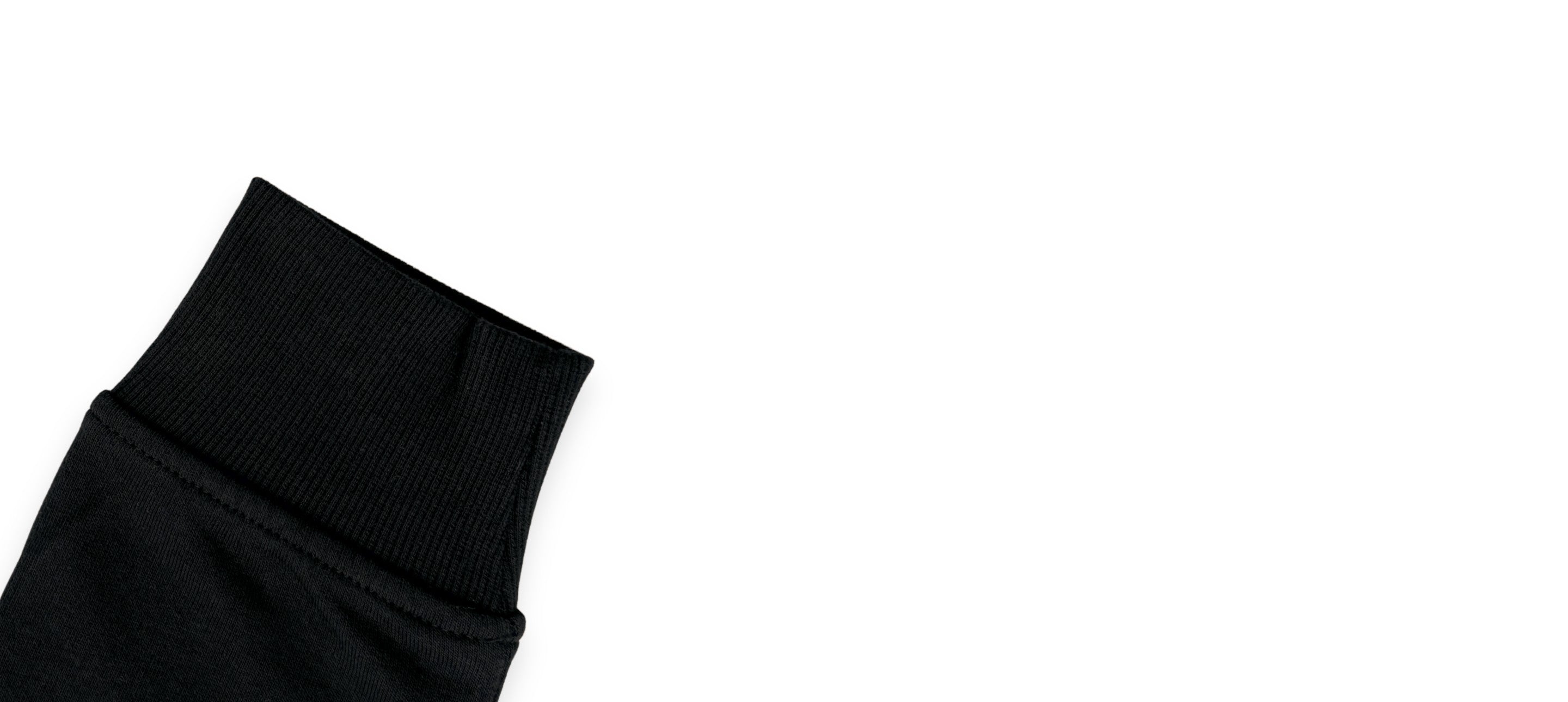 Détail du poignet en bord-côte d’un sweatshirt noir avec finition souple et maintien confortable.