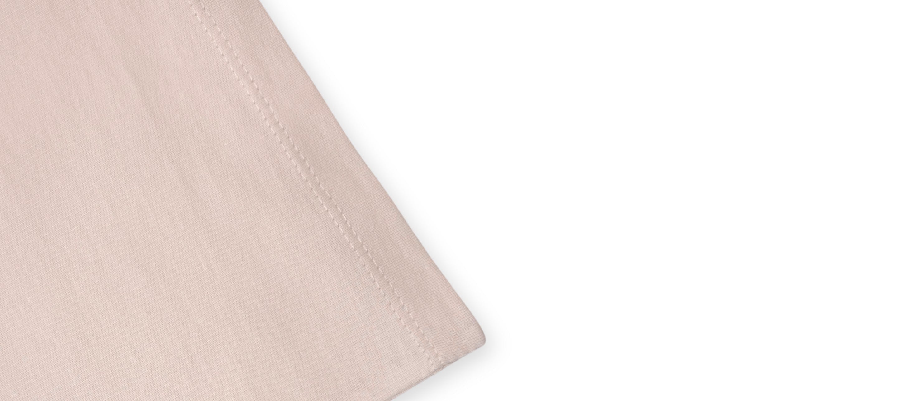 Détail de l’ourlet d’un t-shirt écru avec finition droite et coutures doubles.