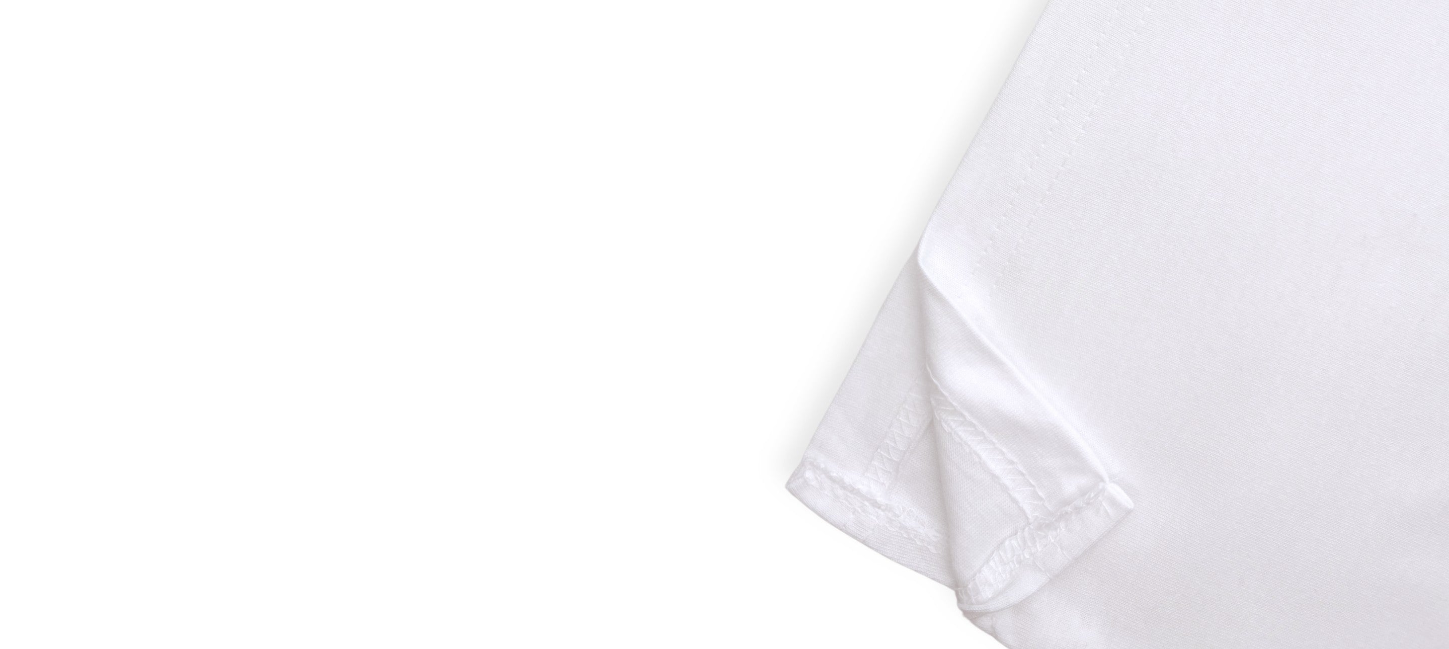 Détail de l’ourlet fendu d’un t-shirt blanc à manches longues avec coutures visibles.