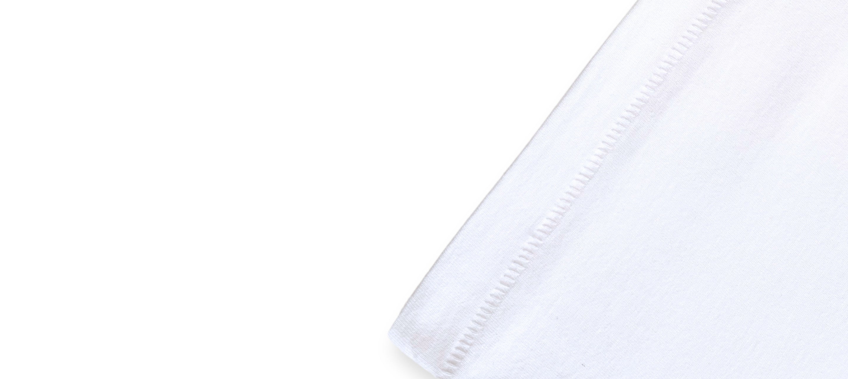 Détail de l’ourlet droit d’un t-shirt blanc oversize avec coutures visibles.
