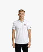 Vue de face d’un homme portant un polo blanc Salut Fred avec broderie « Thérap(e)ute. À votre service » sur la poitrine et Salut Fred brodé sur la manche gauche