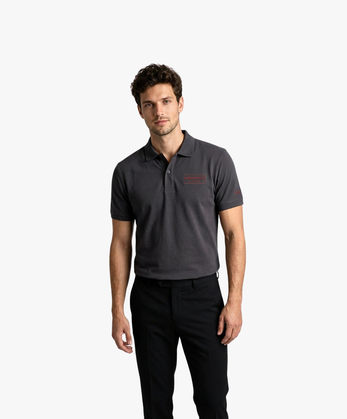 Vue de face d’un homme portant un polo gris graphite Salut Fred avec broderie « Thérap(e)ute. À votre service »