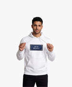 Vue de face d’un homme portant un hoodie blanc Salut Fred avec motif Quai Branly de la collection Rues de France
