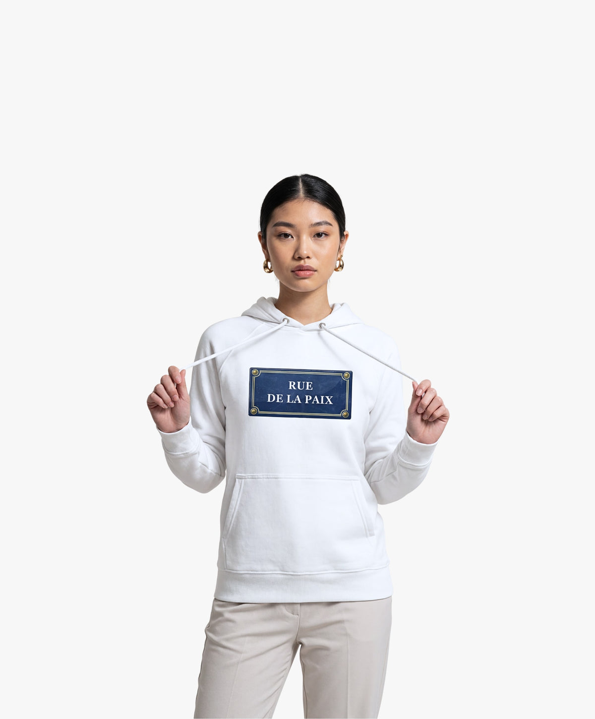 Vue de face d’une femme portant un hoodie blanc Salut Fred avec motif Rue de la Paix de la collection Rues de France