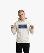 Vue de face d’un homme portant un hoodie écru Salut Fred avec motif Quai Branly de la collection Rues de France
