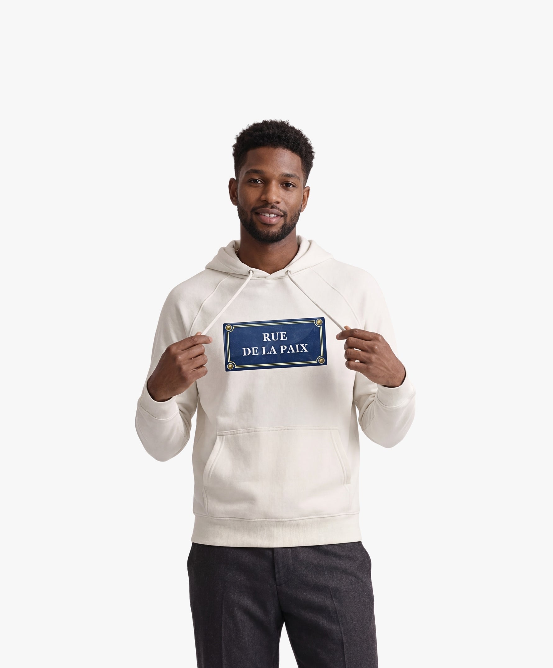 Vue de face d’un homme portant un hoodie écru Salut Fred avec motif Rue de la Paix de la collection Rues de France