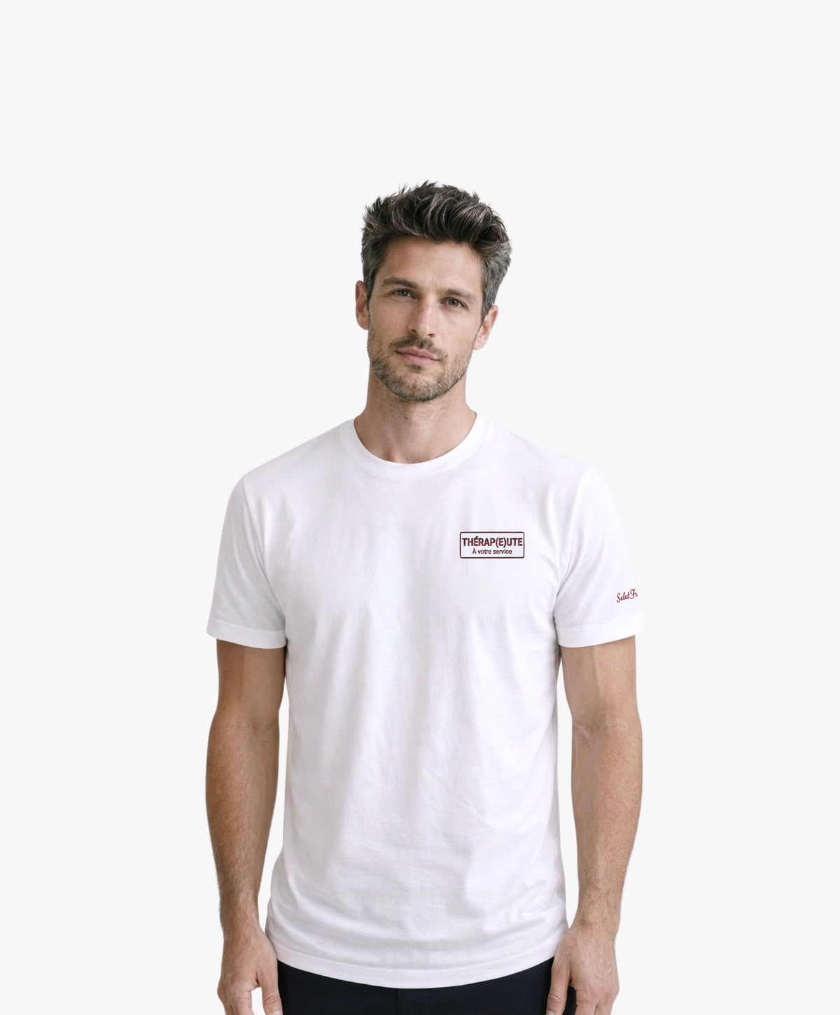 Vue de face d’un homme portant un t-shirt classique blanc Salut Fred avec broderie « Thérap(e)ute À votre service » sur la poitrine gauche