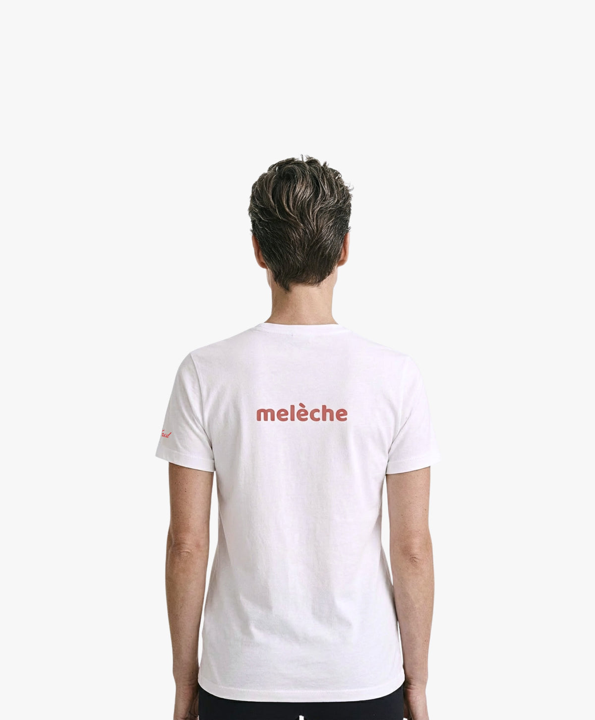 Vue de dos d’une femme portant un t-shirt classique blanc Salut Fred avec melèche imprimé au centre du dos dans une teinte melon pastel saumonée