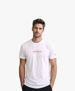 Vue de face d’un homme portant un t-shirt classique blanc Salut Fred avec melon imprimé au centre de la poitrine dans une teinte melon pastel saumonée
