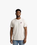 Vue de face d’un homme portant un t-shirt classique écru Salut Fred avec monogramme SF brodé sur la poitrine gauche