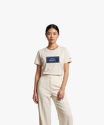 Vue de face d’une femme portant un t-shirt classique écru Salut Fred avec motif Quai Branly de la collection Rues de France