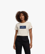 Vue de face d’une femme portant un t-shirt classique écru Salut Fred avec motif Rue de la Paix de la collection Rues de France