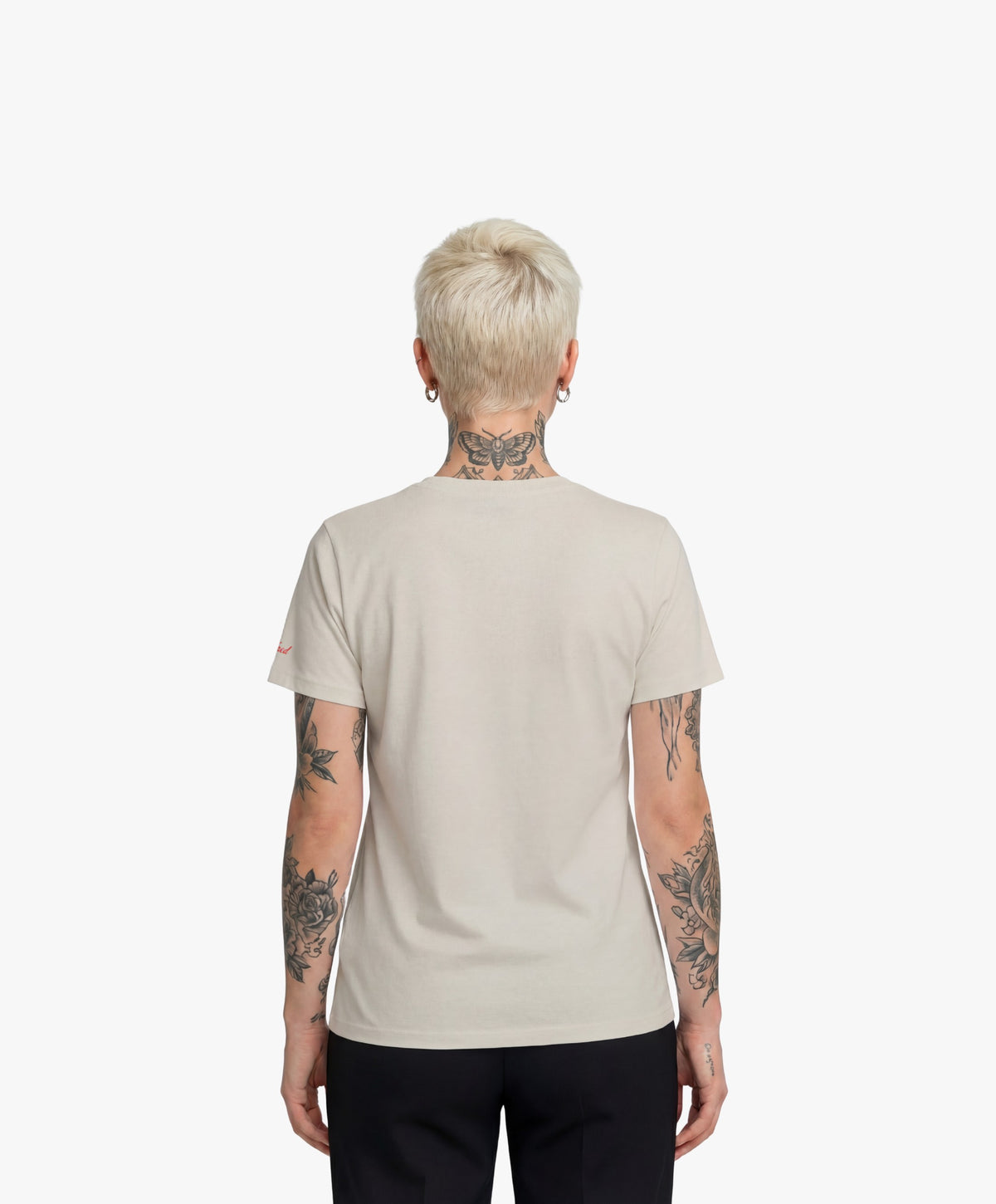 Vue de dos d’une femme portant le t-shirt classique écru « Zizi l’Impératrice » uni au dos avec logo Salut Fred sur la manche gauche.