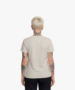 Vue de dos d’une femme portant le t-shirt classique écru « Zizi l’Impératrice » uni au dos avec logo Salut Fred sur la manche gauche.