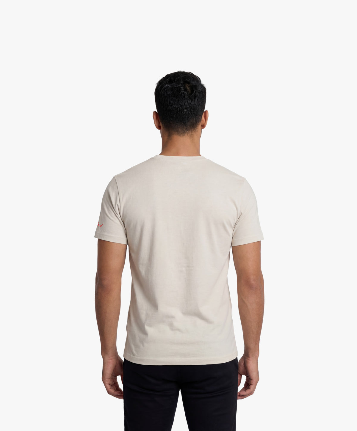 Vue de dos d’un homme portant le t-shirt classique écru « Zizi l’Impératrice » uni au dos avec logo Salut Fred sur la manche gauche.