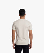 Vue de dos d’un homme portant le t-shirt classique écru « Zizi l’Impératrice » uni au dos avec logo Salut Fred sur la manche gauche.