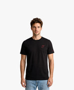 Vue de face d’un homme portant un t-shirt classique noir Salut Fred avec monogramme SF brodé sur la poitrine gauche