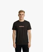 Vue de face d’un homme portant un t-shirt classique noir Salut Fred avec melon imprimé au centre de la poitrine