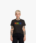 Vue de face d’une femme portant un t-shirt classique noir Salut Fred de la collection Pride « This is not woke. You are just a dick. » avec slogan multicolore imprimé au centre de la poitrine