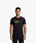 Vue de face d’un homme portant un t-shirt classique noir Salut Fred de la collection Pride « This is not woke. You are just a dick. » avec slogan multicolore imprimé au centre de la poitrine