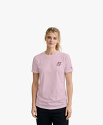 Vue de face d’une femme portant un t-shirt classique rose poudré Salut Fred avec monogramme SF brodé sur la poitrine gauche