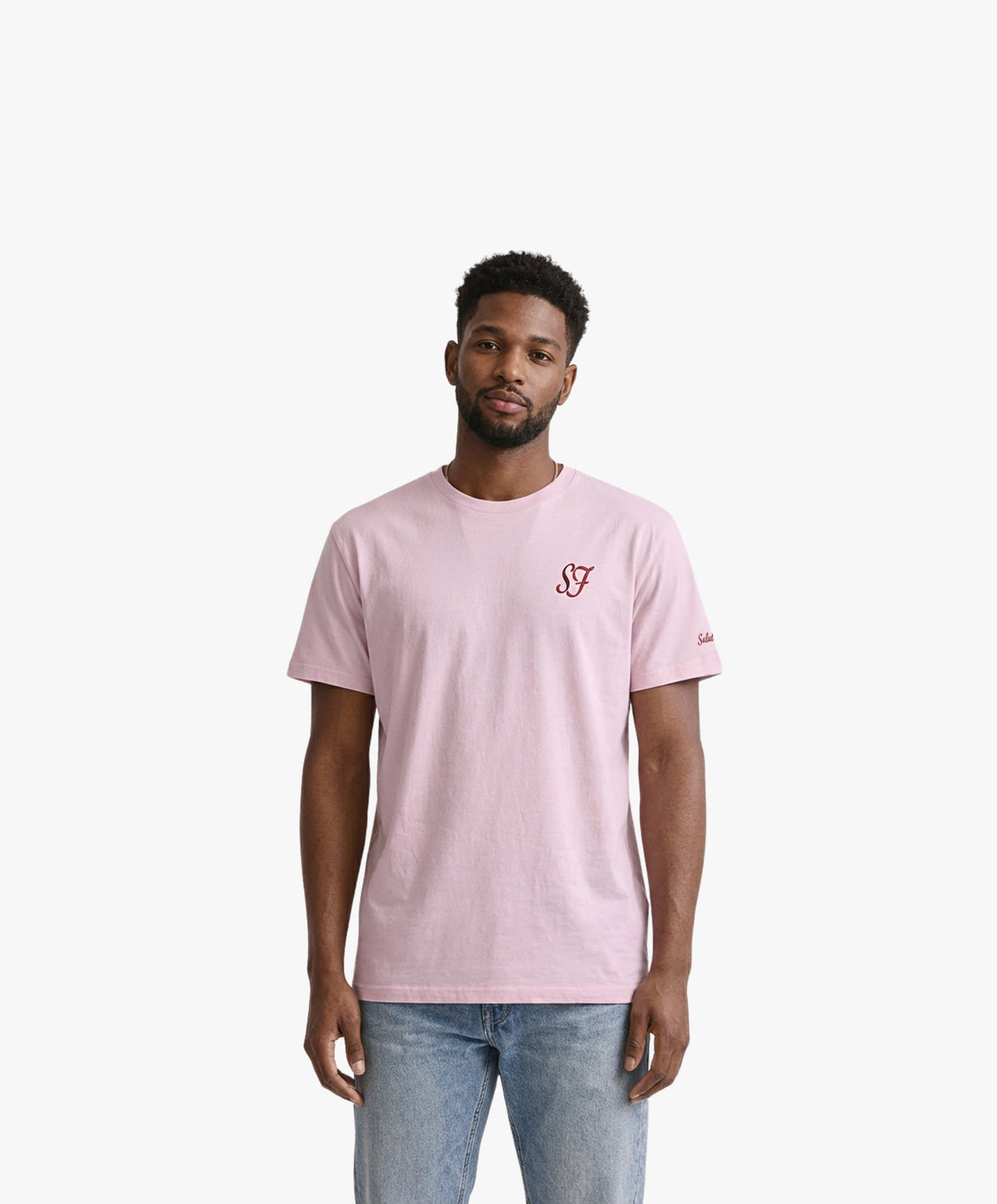 Vue de face d’un homme portant un t-shirt classique rose poudré Salut Fred avec monogramme SF brodé sur la poitrine gauche