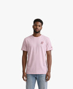 Vue de face d’un homme portant un t-shirt classique rose poudré Salut Fred avec monogramme SF brodé sur la poitrine gauche