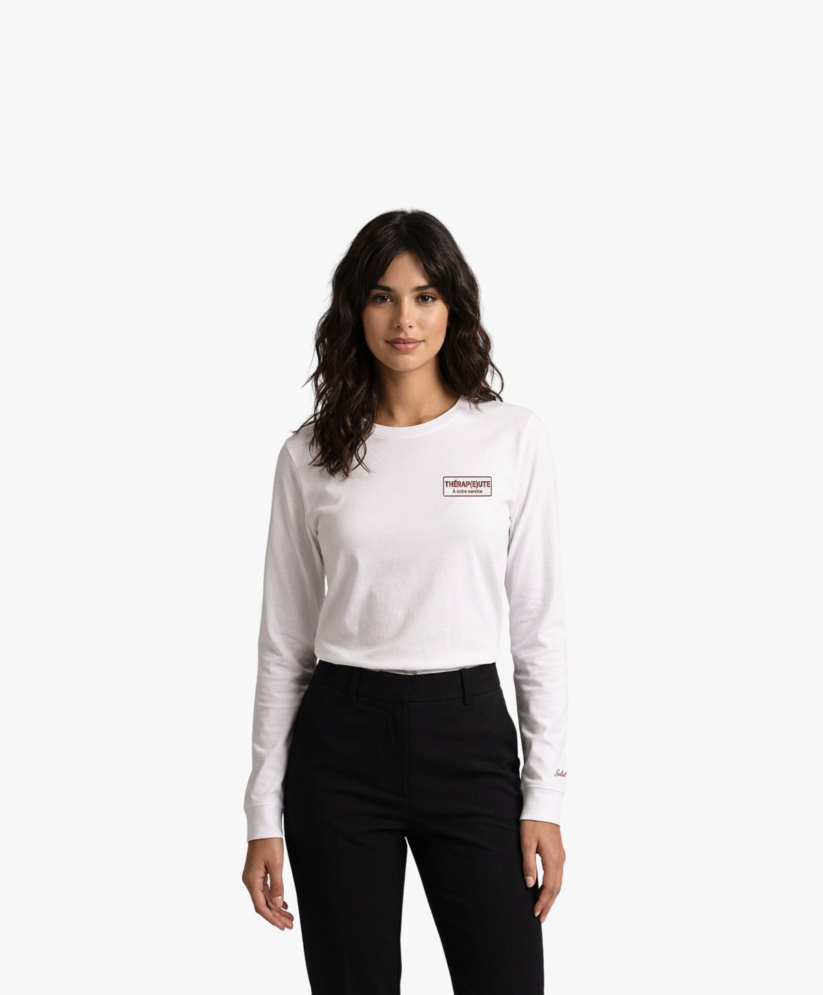 Vue de face d’une femme portant un t-shirt manches longues blanc Salut Fred avec motif brodé « Thérap(e)ute. À votre service » sur la poitrine gauche