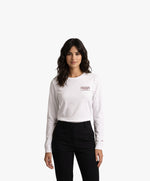 Vue de face d’une femme portant un t-shirt manches longues blanc Salut Fred avec motif brodé « Thérap(e)ute. À votre service » sur la poitrine gauche