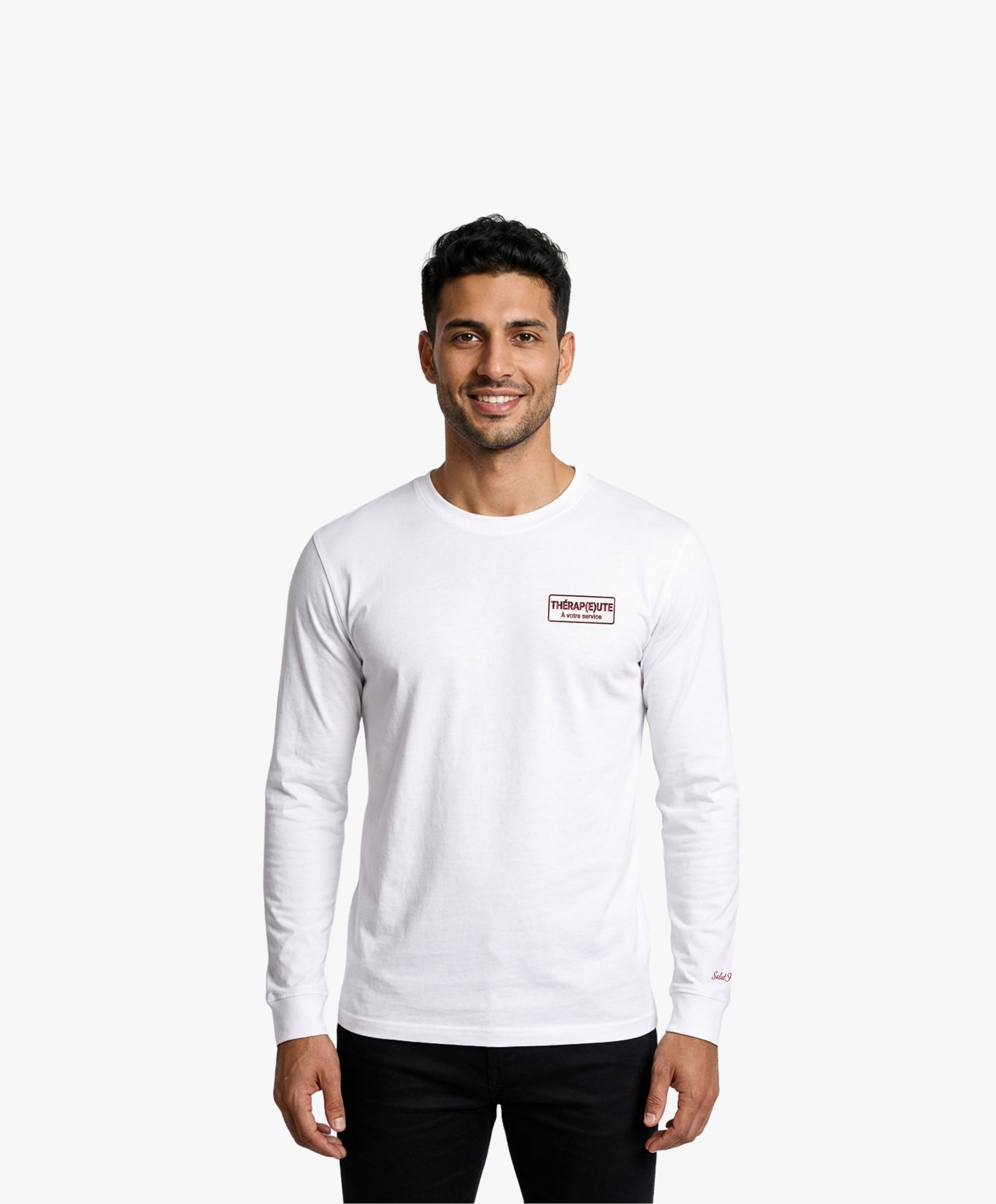 Vue de face d’un homme portant un t-shirt manches longues blanc Salut Fred avec motif brodé « Thérap(e)ute. À votre service » sur la poitrine gauche