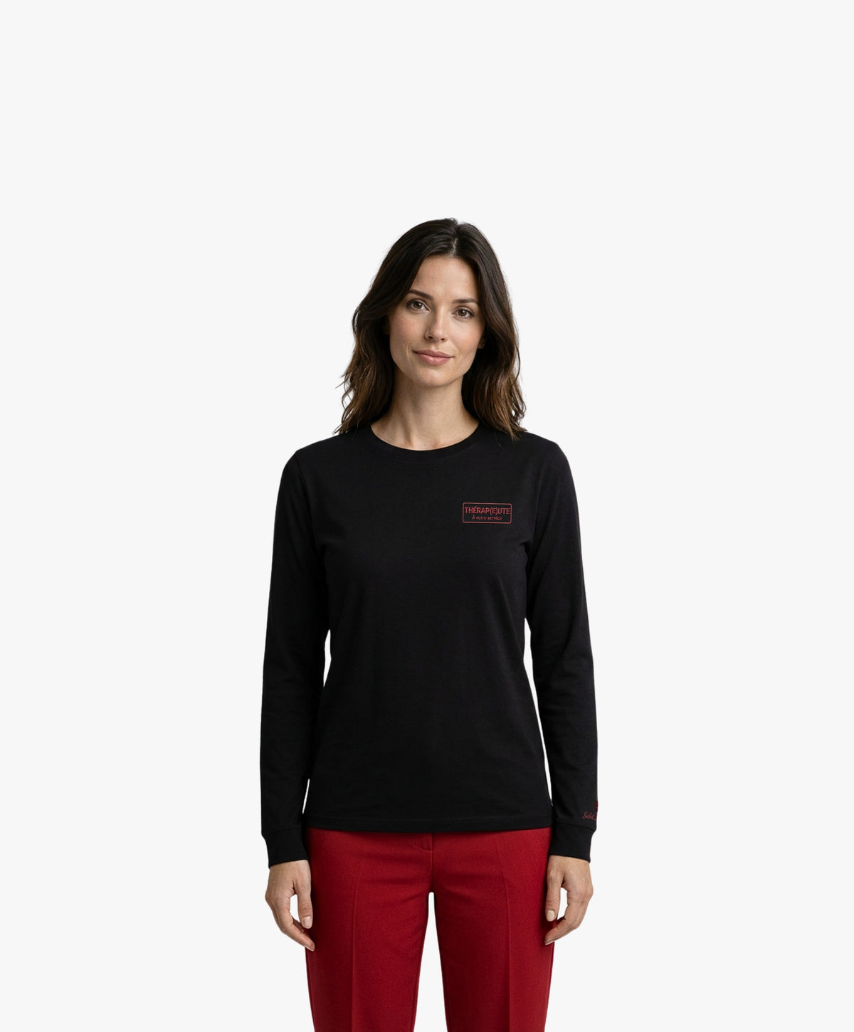 Vue de face d’une femme portant un t-shirt manches longues noir Salut Fred avec motif brodé « Thérap(e)ute. À votre service » sur la poitrine gauche