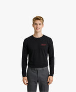 Vue de face d’un homme portant un t-shirt manches longues noir Salut Fred avec motif brodé « Thérap(e)ute. À votre service » sur la poitrine gauche