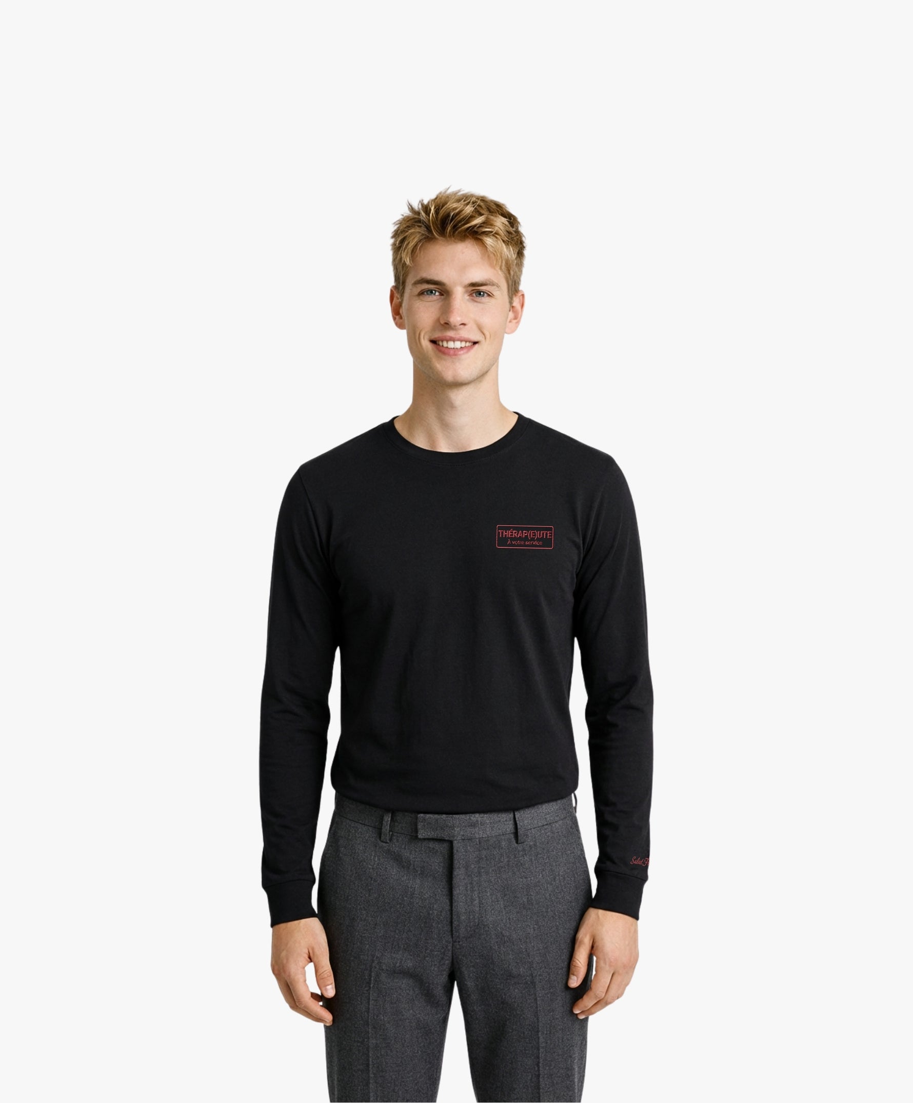 Vue de face d’un homme portant un t-shirt manches longues noir Salut Fred avec motif brodé « Thérap(e)ute. À votre service » sur la poitrine gauche