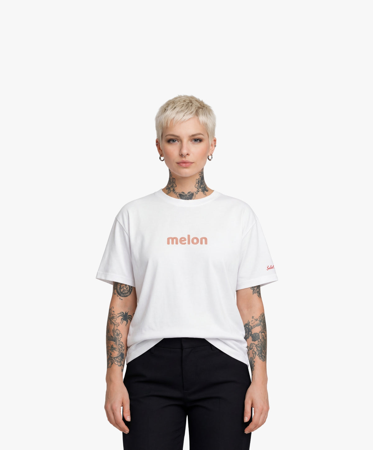 Femme vue de face portant le t-shirt oversize blanc « Melon Melèche » avec texte imprimé « melon » centré sur la poitrine et logo Salut Fred sur la manche gauche.
