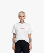 Femme vue de face portant le t-shirt oversize blanc « Melon Melèche » avec texte imprimé « melon » centré sur la poitrine et logo Salut Fred sur la manche gauche.