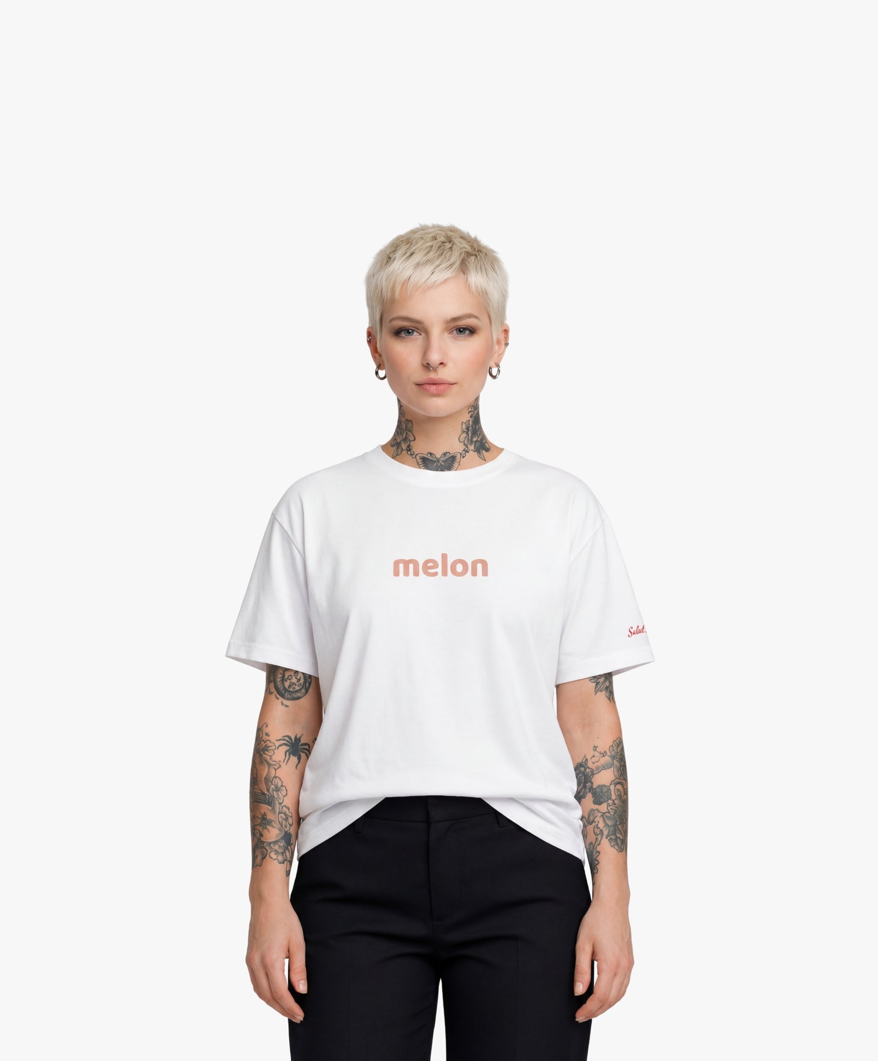 Femme vue de face portant le t-shirt oversize blanc « Melon Melèche » avec texte imprimé « melon » centré sur la poitrine et logo Salut Fred sur la manche gauche.