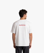 Homme vue de dos portant le t-shirt oversize blanc « Melon Melèche » avec texte imprimé « melèche » centré dans le dos.