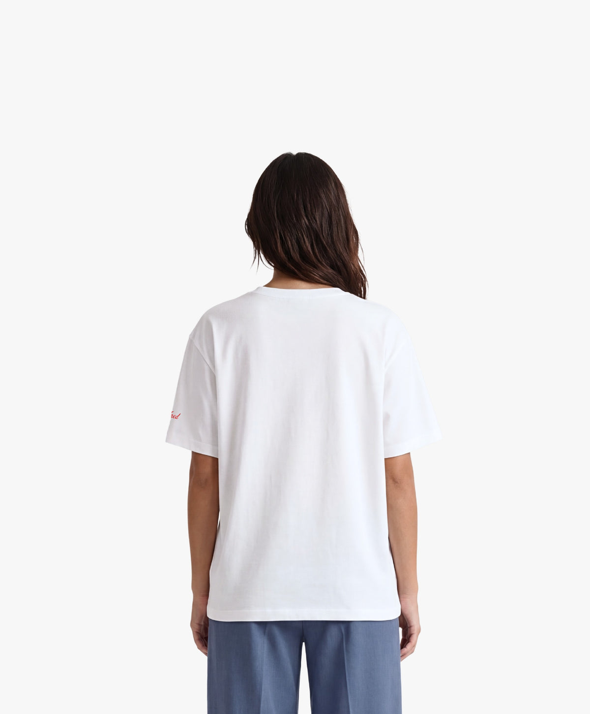 Vue de dos d’une femme portant un t-shirt oversize blanc Salut Fred avec motif Quai Branly de la collection Rues de France