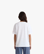 Vue de dos d’une femme portant un t-shirt oversize blanc Salut Fred avec motif Quai Branly de la collection Rues de France