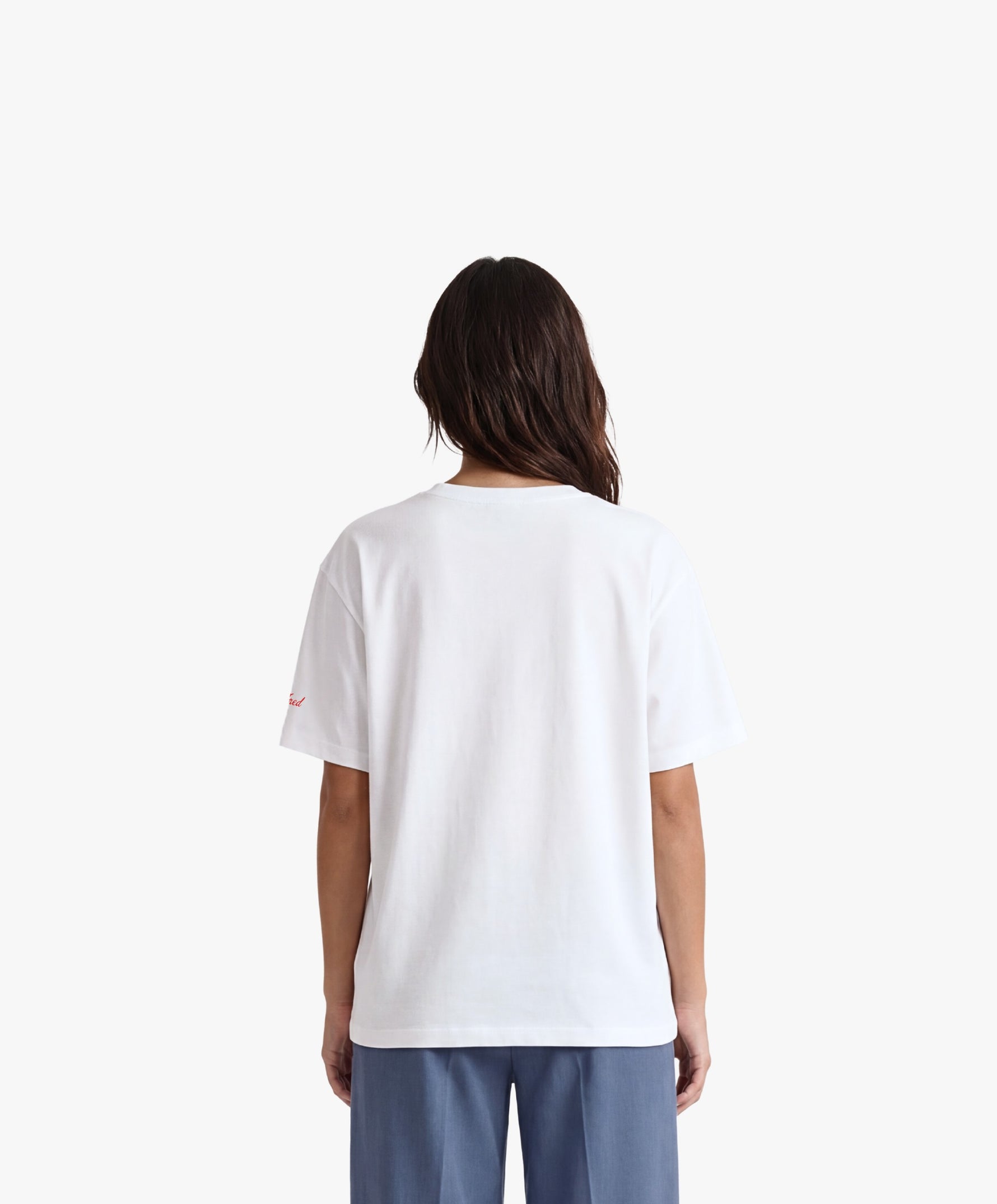 Vue de dos d’une femme portant un t-shirt oversize blanc Salut Fred avec motif Quai Branly de la collection Rues de France