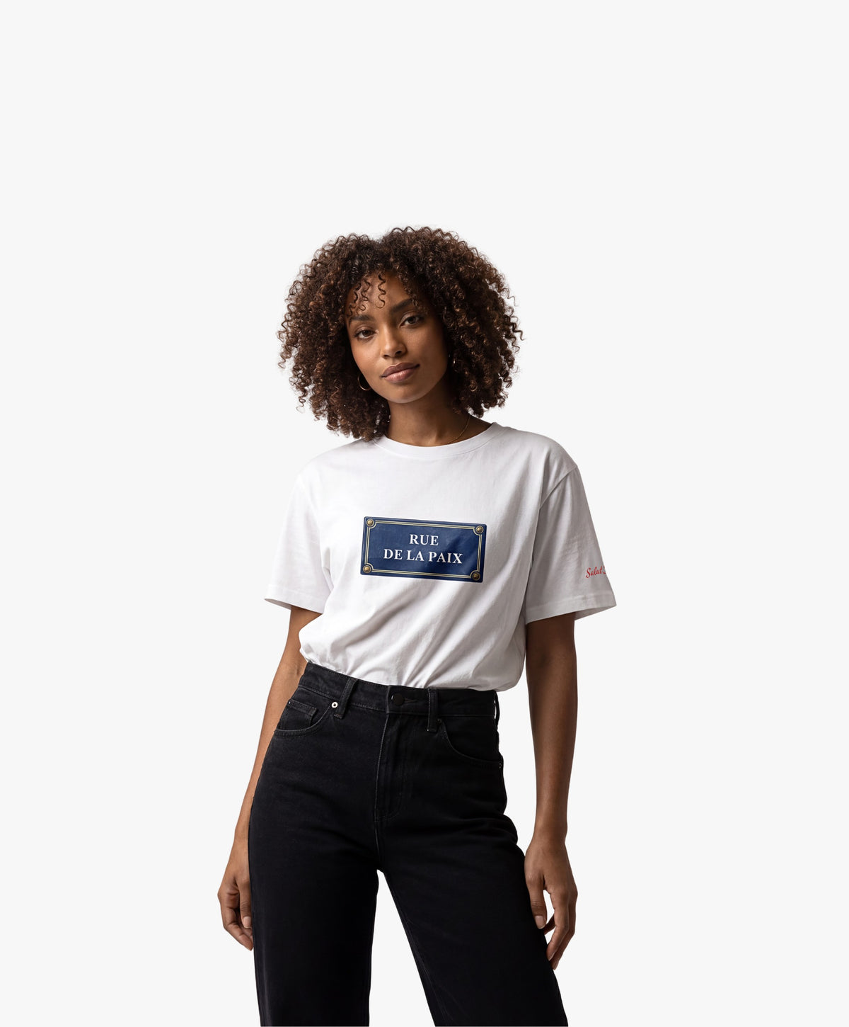 Vue de face d’une femme portant un t-shirt oversize blanc Salut Fred avec motif Rue de la Paix de la collection Rues de France