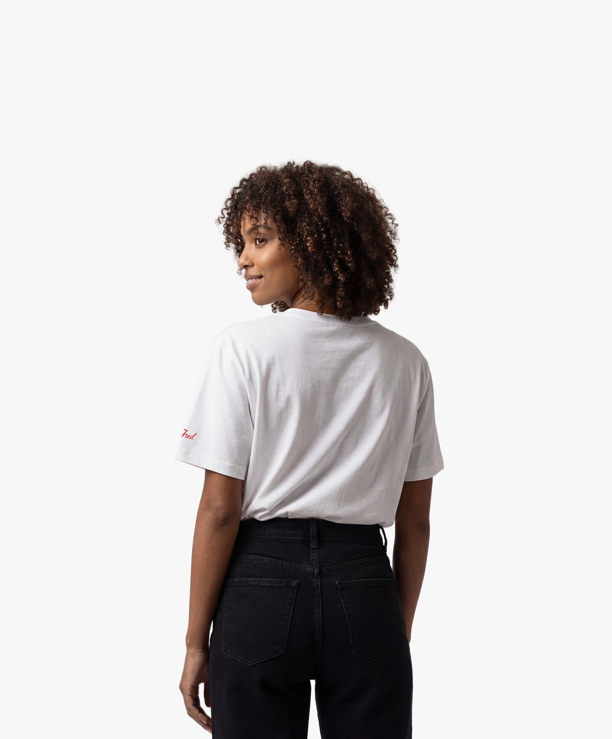 Vue de dos d’une femme portant un t-shirt oversize blanc Salut Fred avec motif Rue de la Paix de la collection Rues de France