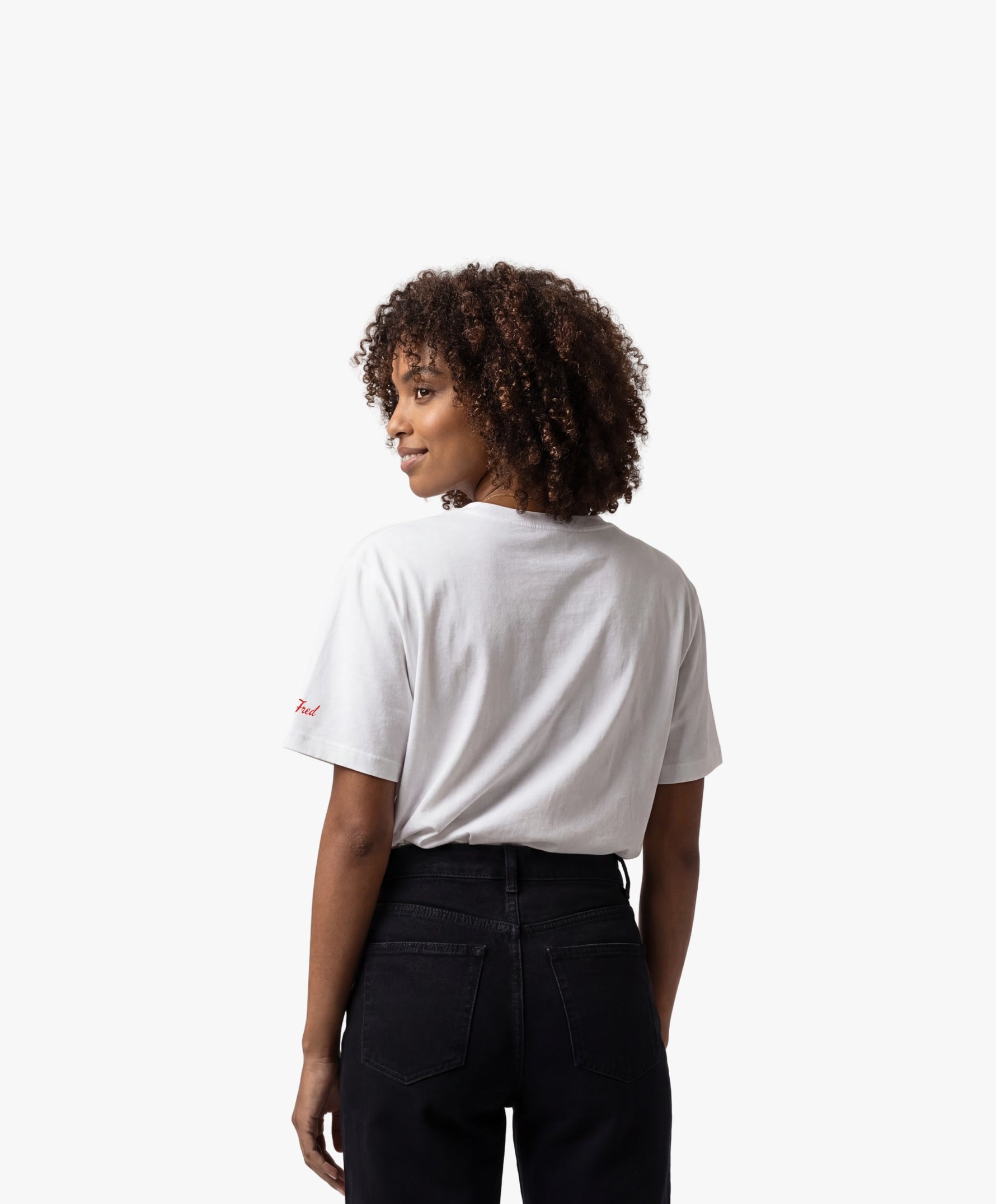Vue de dos d’une femme portant un t-shirt oversize blanc Salut Fred avec motif Rue de la Paix de la collection Rues de France